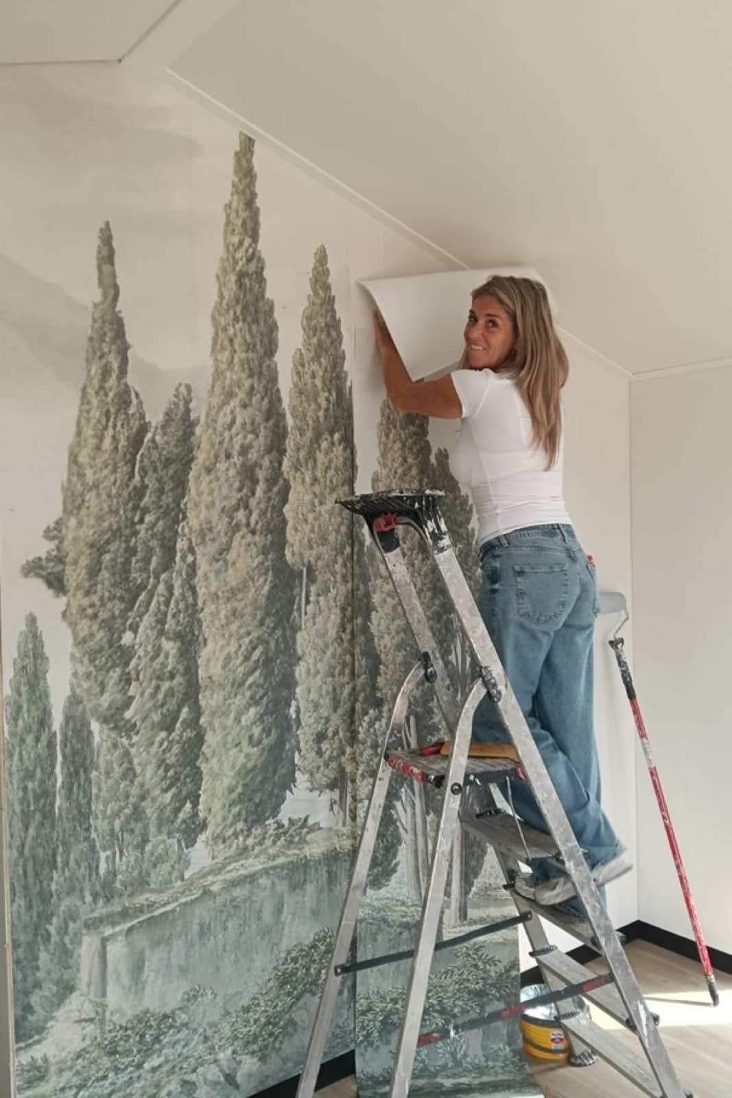 Miranda van den Brink aan het werk aan een wand